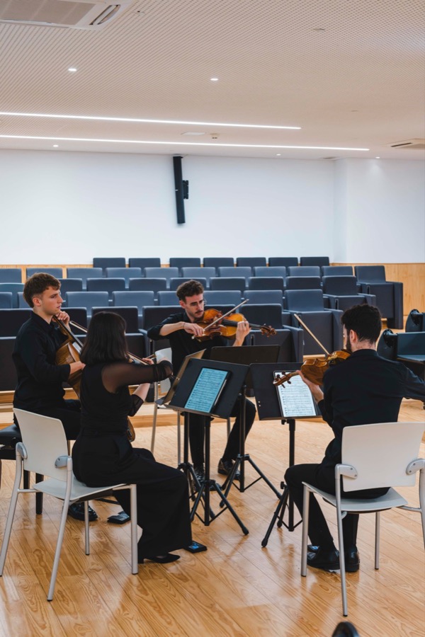 Luscofusco Quartet rehearsing in a concert hall, seated in a circle around music stands